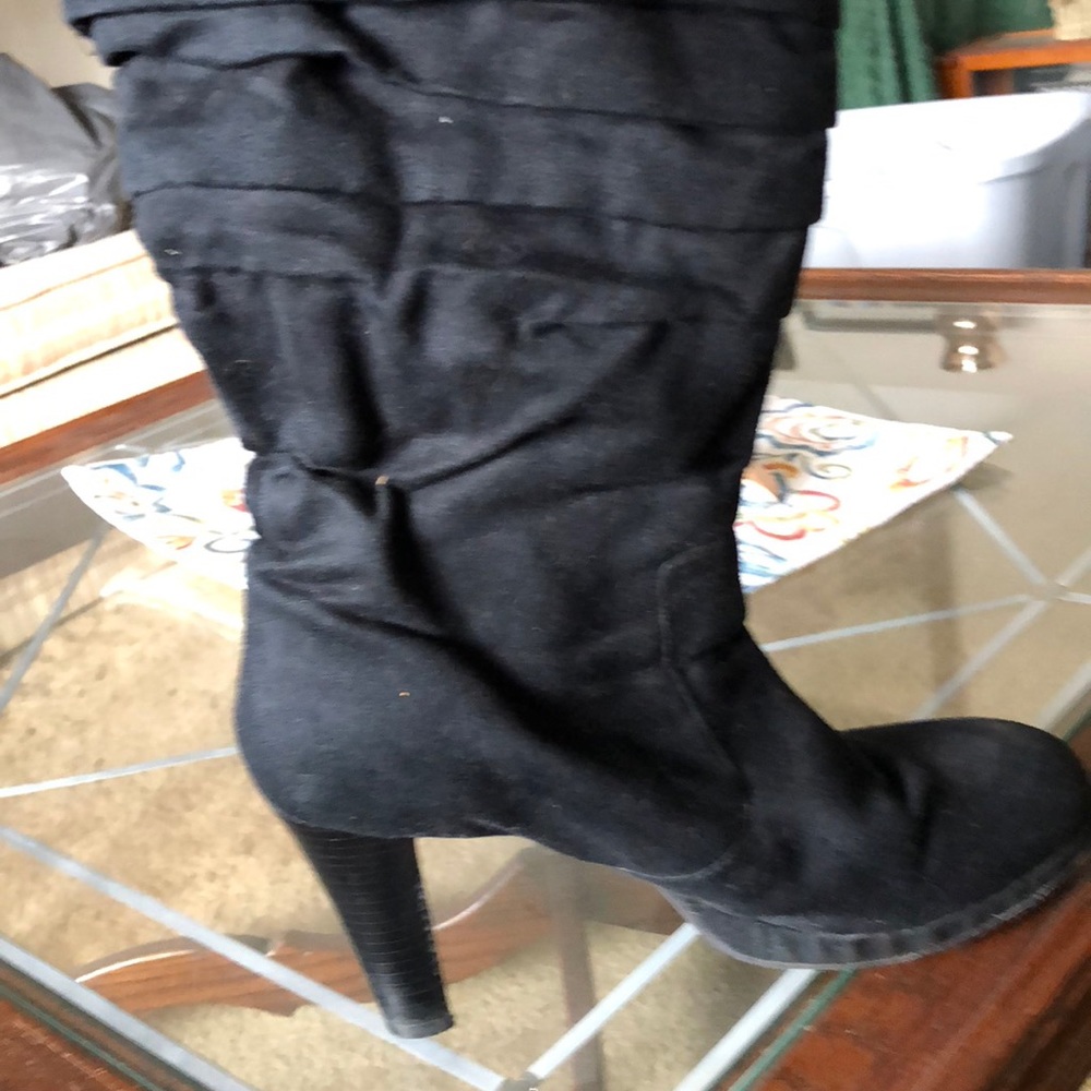 Black suede boots with platform heel .